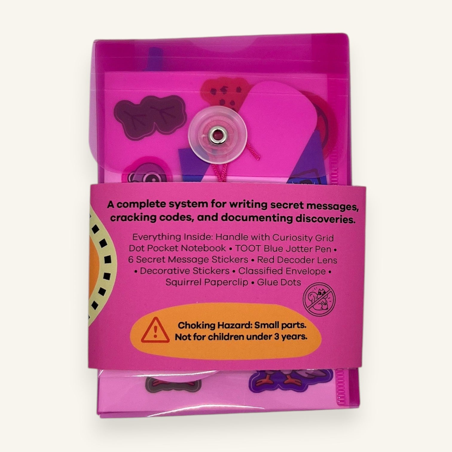 The Curiosity Route Classified Curiosities Kit in a pink envelope with secret message tools, stickers, and notebook.