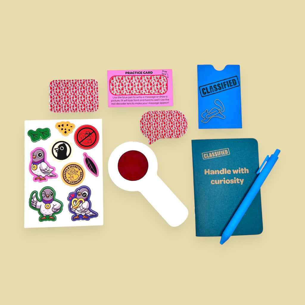 The Curiosity Route Classified Curiosities Kit with a grid-dot notebook, blue pen, decoder lens, and secret stickers.