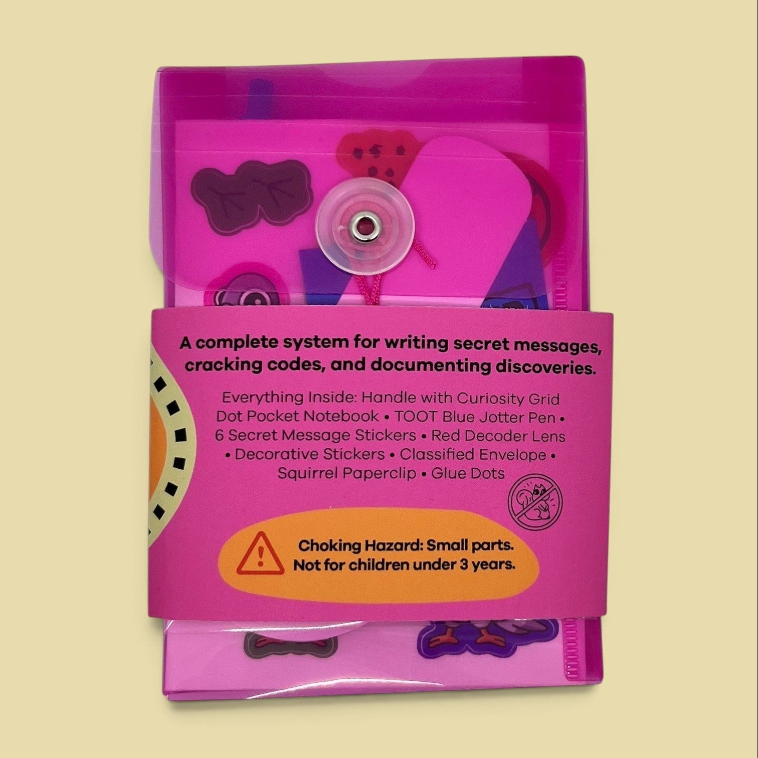 The Curiosity Route Classified Curiosities Kit in a pink envelope with secret message tools, stickers, and notebook.