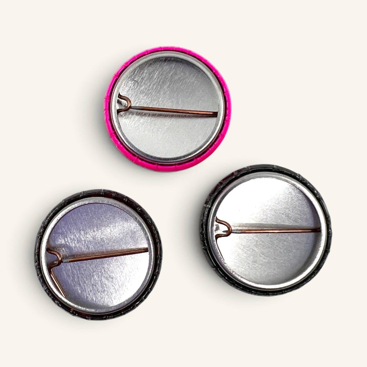 The Curiosity Route DoSS button pack showing the metal pin backs of three 1-inch circular pinback buttons