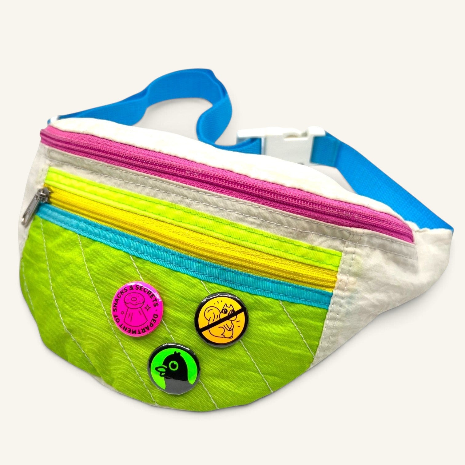 The Curiosity Route DoSS button pack featuring three 1-inch pins attached to a colorful neon green fanny pack.