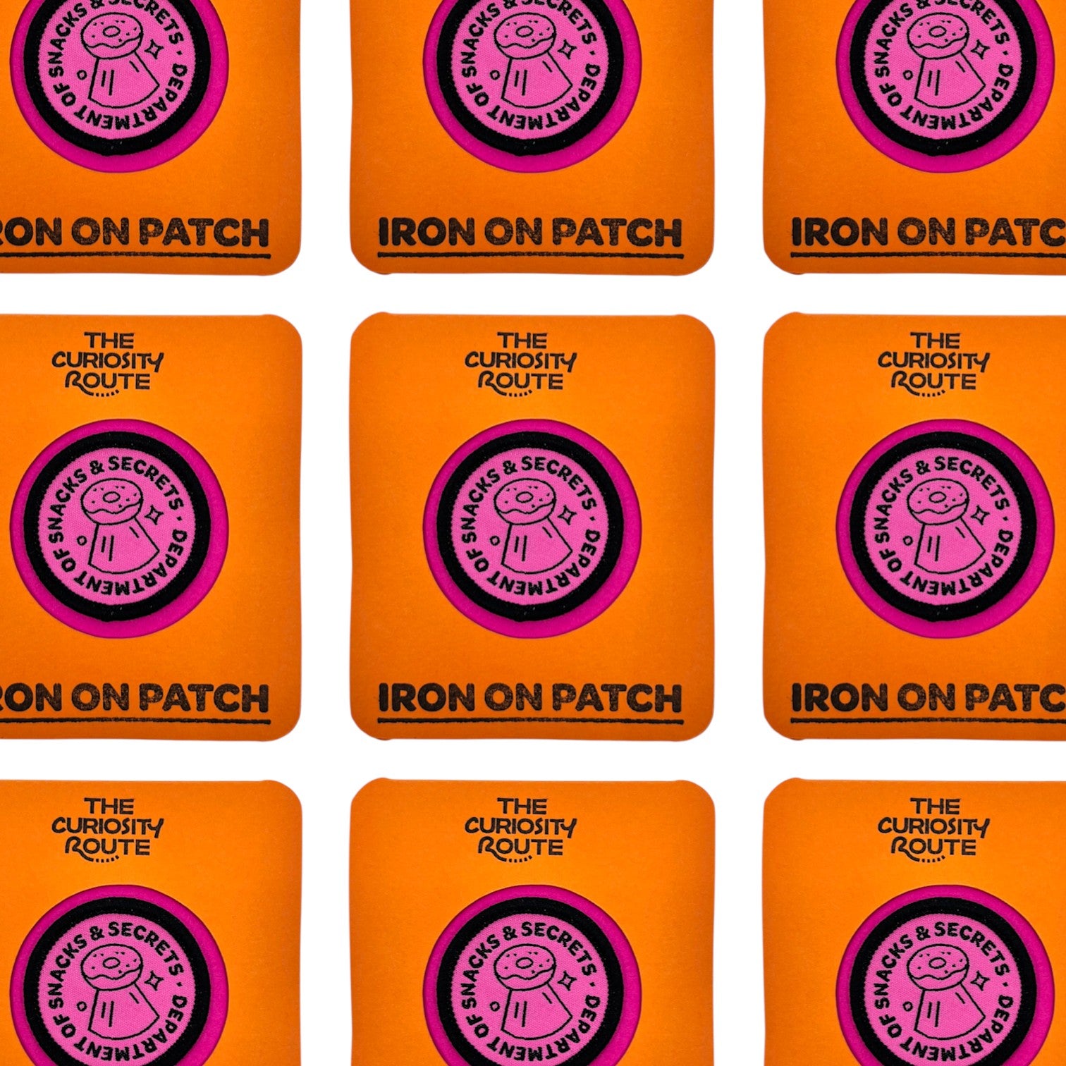 The Curiosity Route circular pink embroidered patch featuring a donut icon and Department of Snacks and Secrets text.