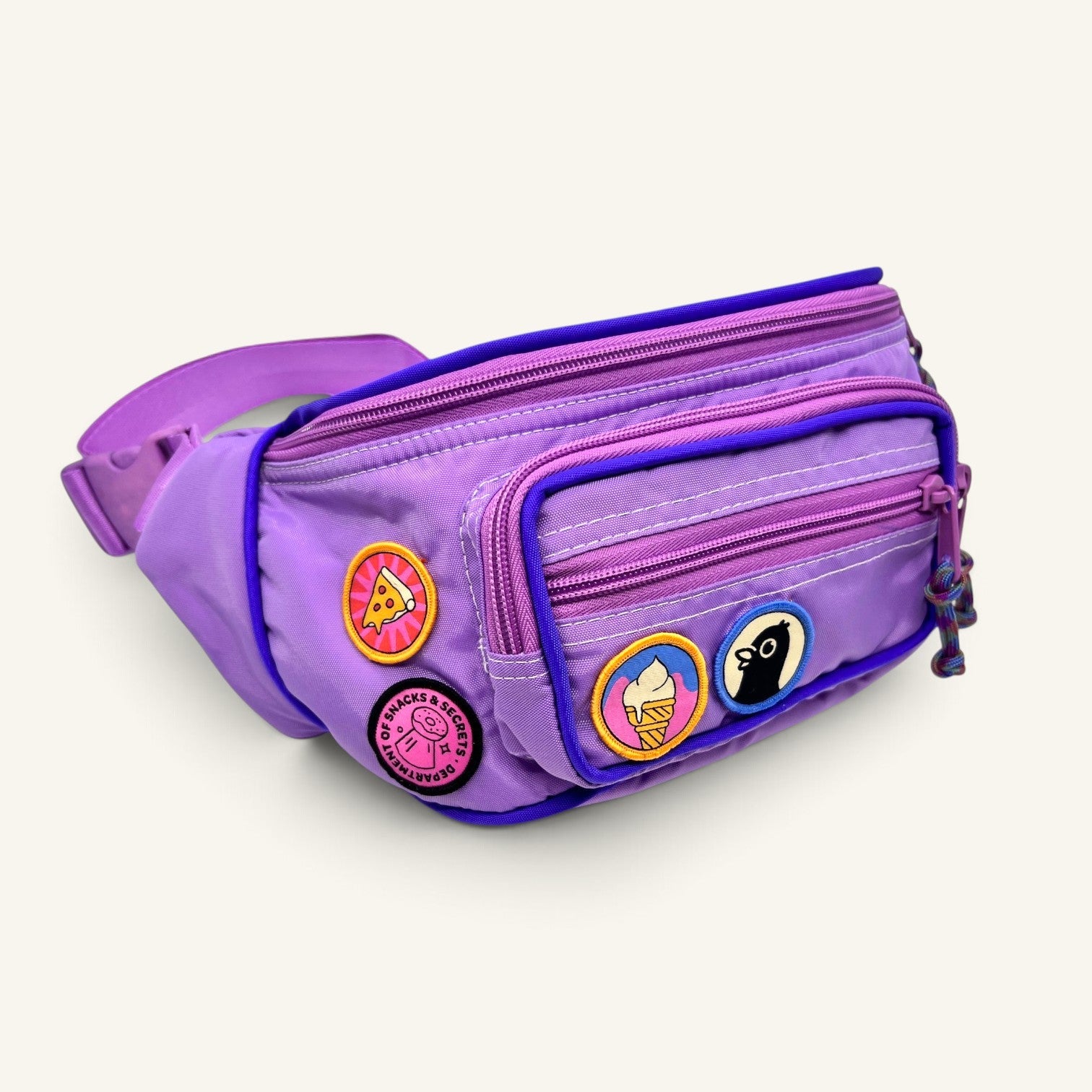 The Curiosity Route Slice Squad pizza patch attached to a purple fanny pack with other fun embroidered patches.